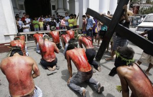 Filipino-flagellants-kneel-in-front-of-the-church-as-they-perform-rites-meant-to-atone-for-sins-at-San-Fernando-city-Pampanga-province-northern-Philippines-on-Maundy-Thursday-April-9-2009.-Many-Philippine-devotees-practice-fla